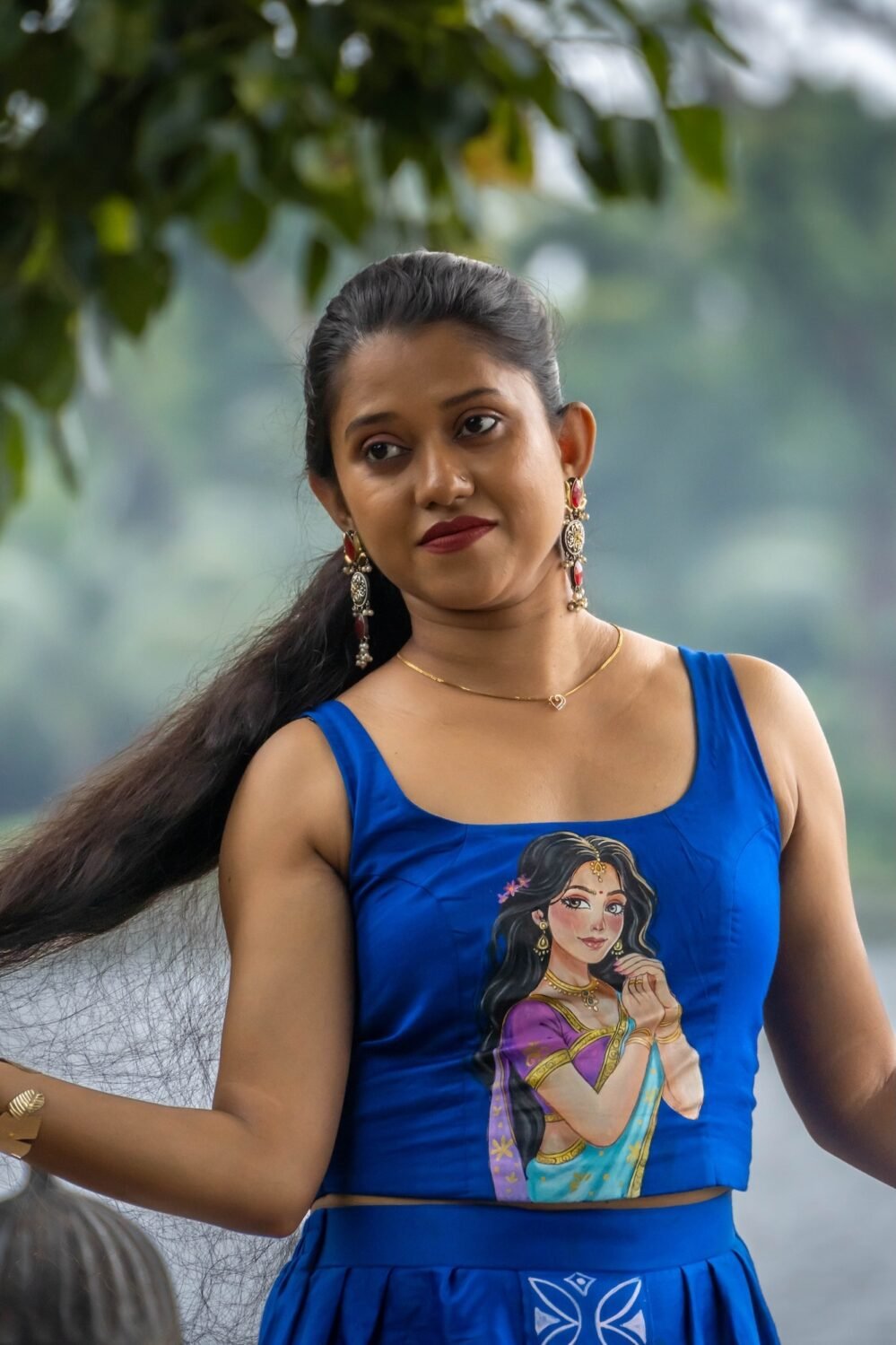 Close-up of royal blue hand painted crop blouse featuring female portrait art by Aankibukis Couture