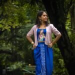 Model posing outdoors in CharuNeela 3-piece hand painted royal blue dhoti set by Aankibukis Couture