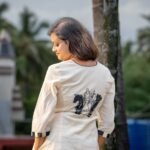Closeup view in portrait style of white Kora Khadi co-ord set featuring handpainted chess piece artwork on the back