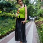 Full-length view of the Flora Canvas skirt co-ord featuring a hand-painted neon green top on a garden walkway