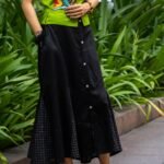 Close-up of model placing hand inside the side pocket of the Flora Canvas black cotton skirt set