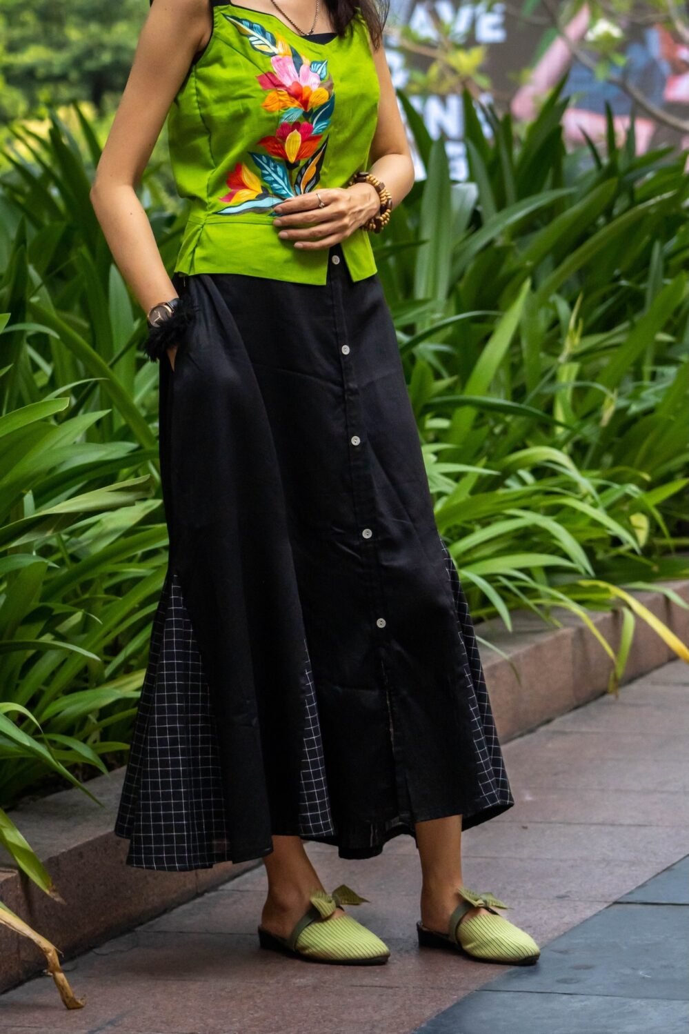 Close-up of model placing hand inside the side pocket of the Flora Canvas black cotton skirt set