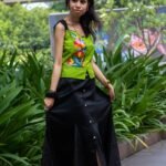 Model lifting the sides of the Flora Canvas black skirt showcasing the check koli lower hem panels