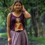 Front view of woman wearing sleeveless Malai cotton top featuring artisan painting of Maa Durga.