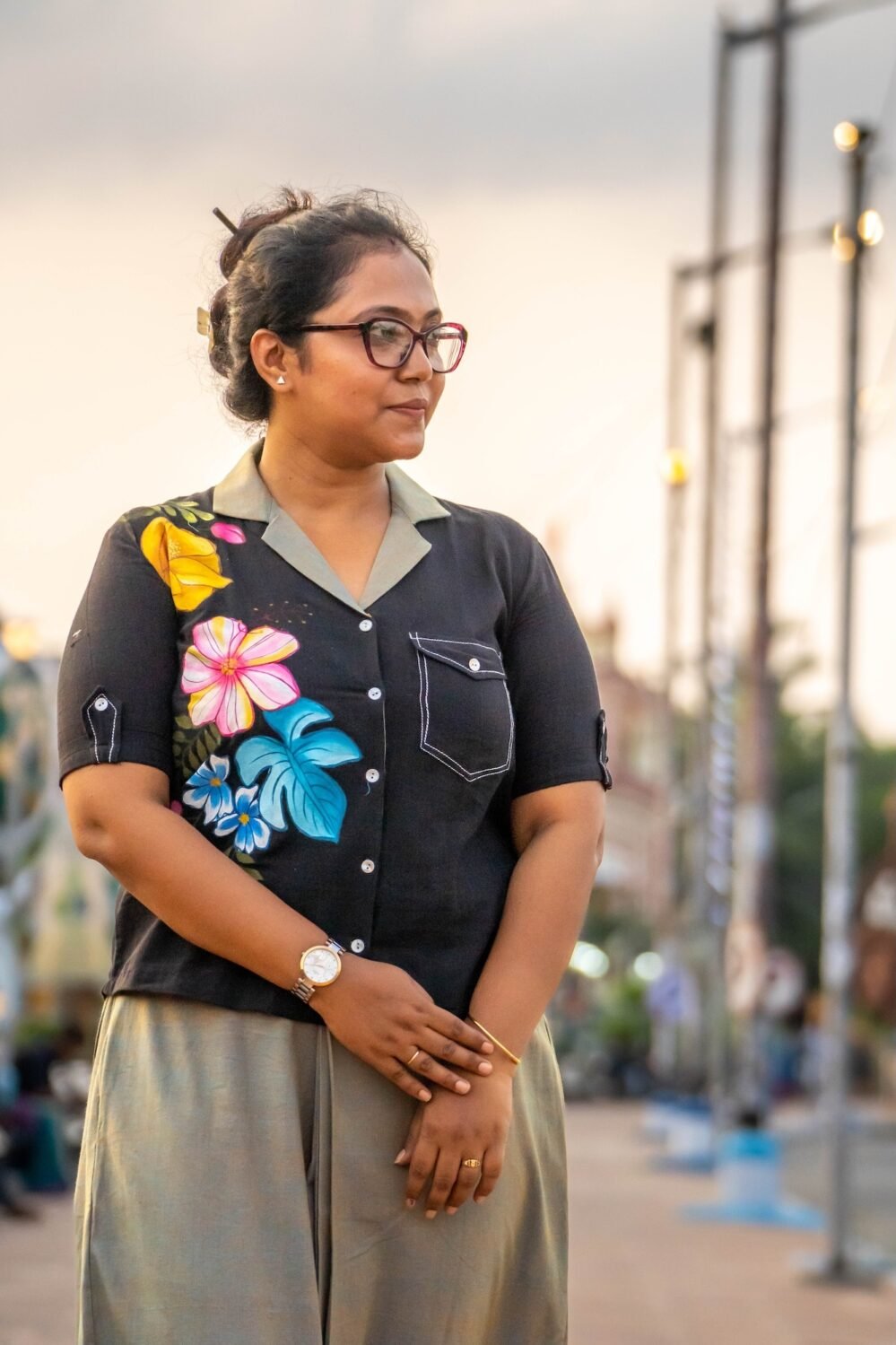 Close-up portrait highlighting the blazer collar and shoulder hand-painted yellow and pink floral art on a black handloom cotton shirt.