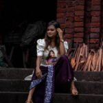 Full view of the Indo western fusion set sitting on stair and flow of the 36-inch dhoti.