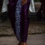 Close-up of white hand painted kalka paisley motif along the draped purple dhoti pants.