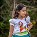 Close-up shot showing the hand-painted cartoon artwork of Maa Durga and lion on a white puff-sleeve top for girls.