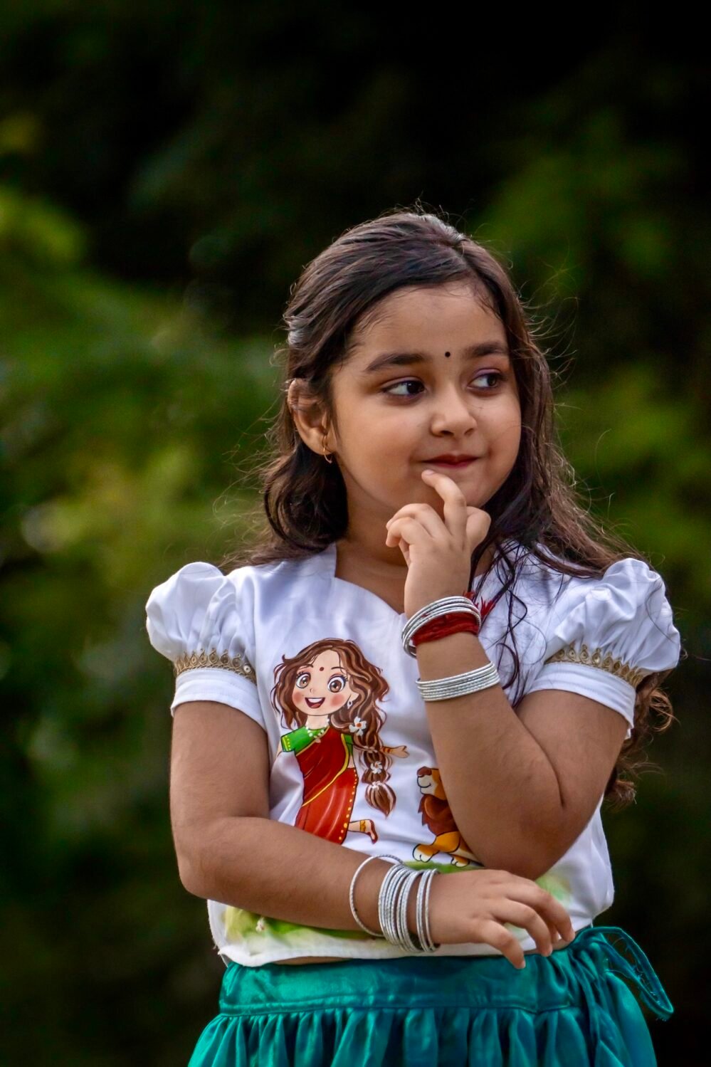 Detailed upper shot of a girl wearing a white malai cotton top featuring hand-painted Maa Durga art and gold lace trim.
