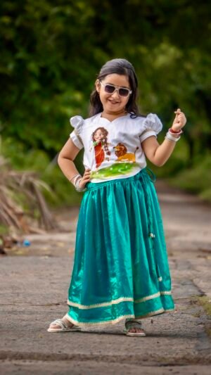 Little girl wearing sunglasses posing in Aankibukis Couture Kanya Durga skirt set with hand-painted Maa Durga top and peacock green skirt