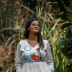 Half-length portrait of a smiling woman wearing the Kora Moon Light handpainted co-ord top.