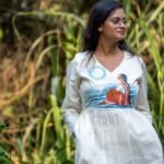 Upper-body shot of woman in v-neck handpainted kora khadi co-ord top in an outdoor setting.
