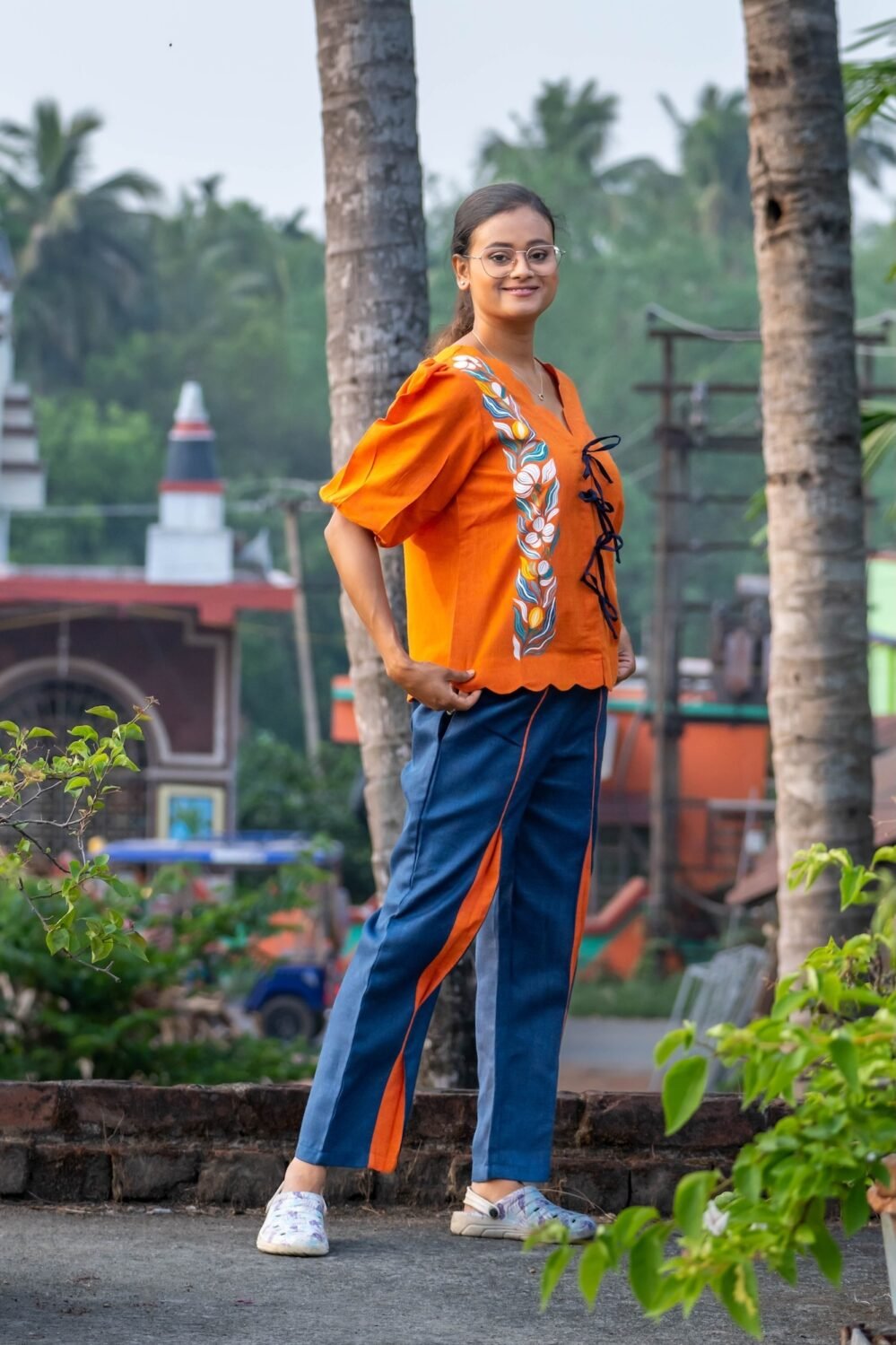 Woman wearing handpainted orange khadi top with scalloped hem and blue lava concept pants by Aankibukis Couture.