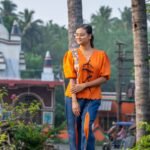 Woman posing in LAVA handpainted orange and blue co-ord set for comfortable daily workwear.