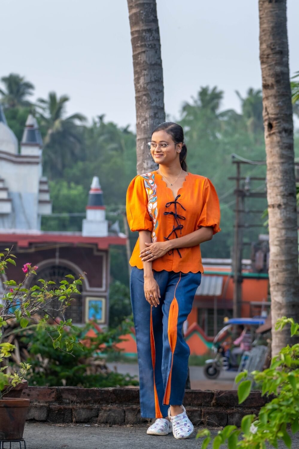 Woman posing in LAVA handpainted orange and blue co-ord set for comfortable daily workwear.
