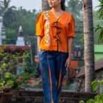 Full shot of woman walking in handpainted LAVA co-ord set featuring pockets and scallop hem.