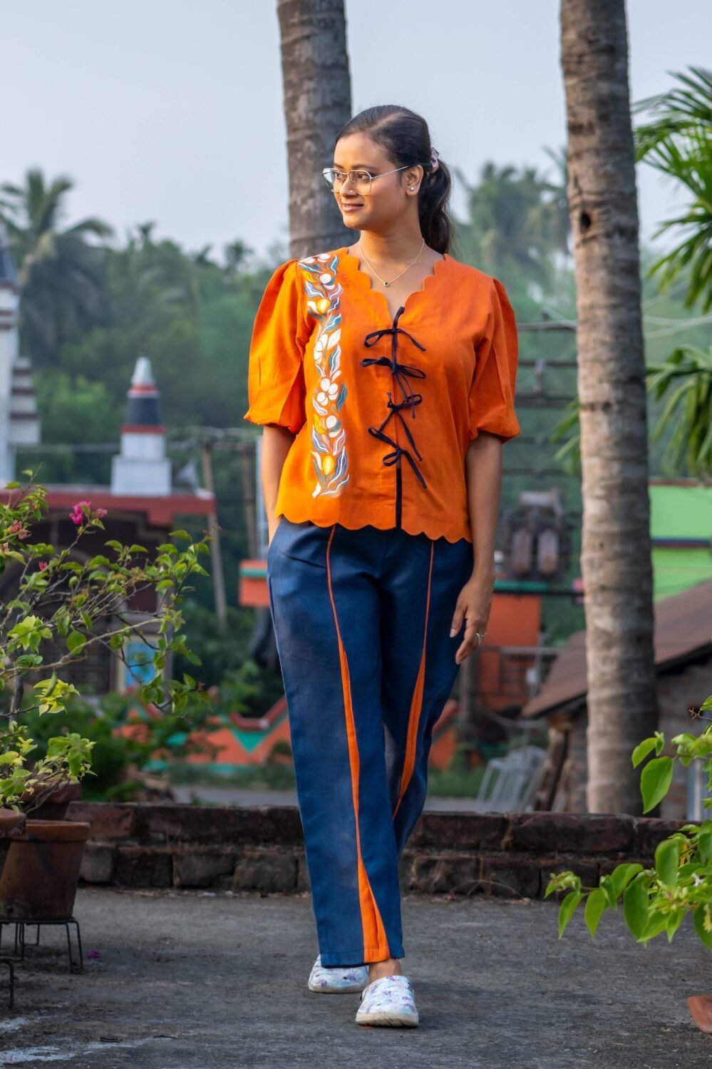 Full shot of woman walking in handpainted LAVA co-ord set featuring pockets and scallop hem.