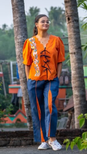 Full length front view of LAVA handpainted co-ord set with orange doori shirt and blue contrast panel pants.