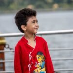 Upper body portrait of boy wearing vibrant red hand painted cotton ethnic kurta with traditional Indian artwork by Aankibukis Couture