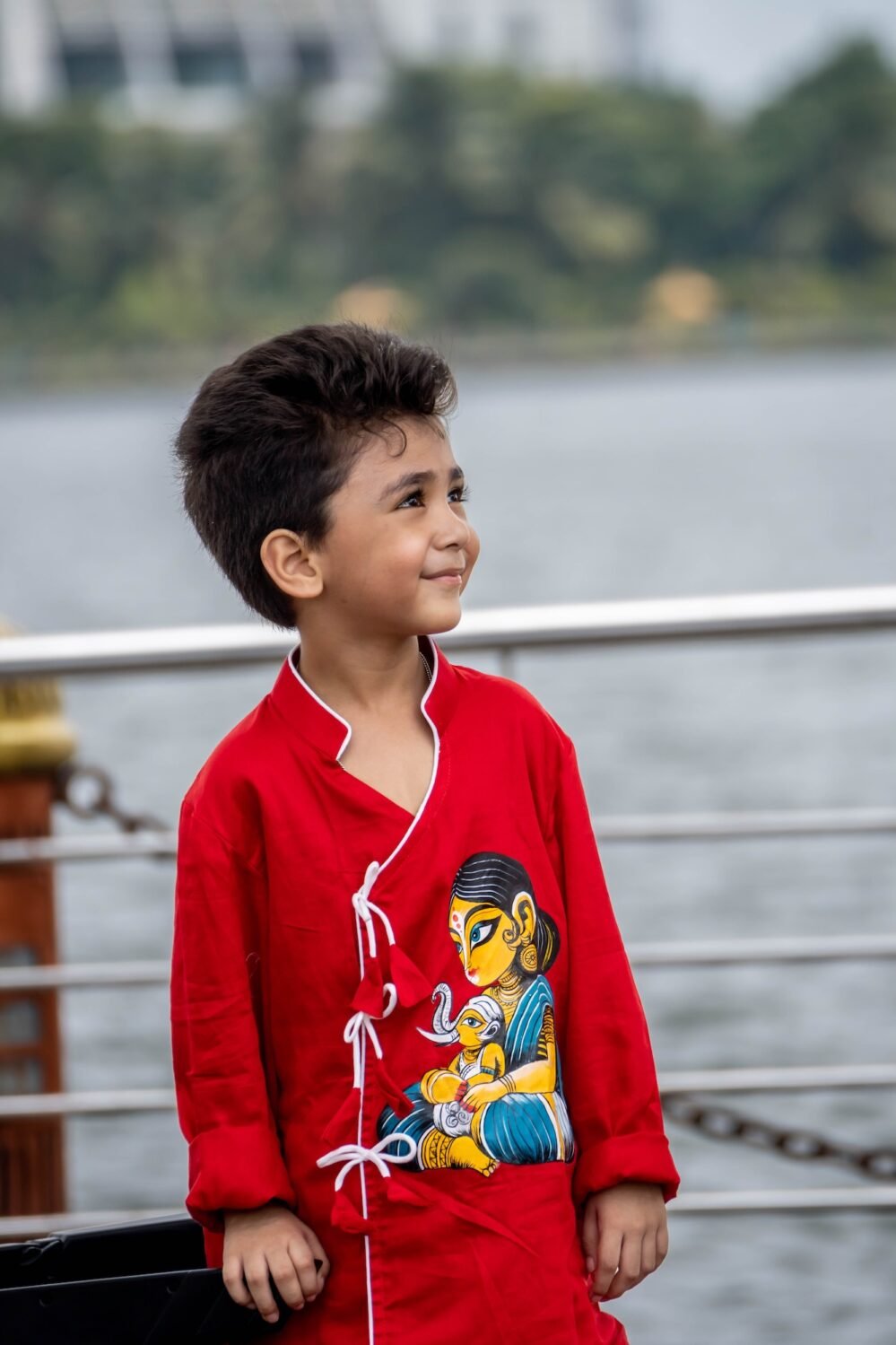 Upper body portrait of boy wearing vibrant red hand painted cotton ethnic kurta with traditional Indian artwork by Aankibukis Couture