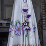 Close-up detail of the handcrafted purple and white waist tassels and handpainted floral hemline on the Nilaambari lehenga skirt.