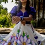 High-angle shot highlighting the intricate purple handpainted floral artwork and fabric texture of the Nilaambari lehenga skirt by Aankibukis Couture.