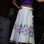 Medium shot highlighting the fit, hemline border, and handpainted violet botanical artwork on the Nilaambari lehenga set.
