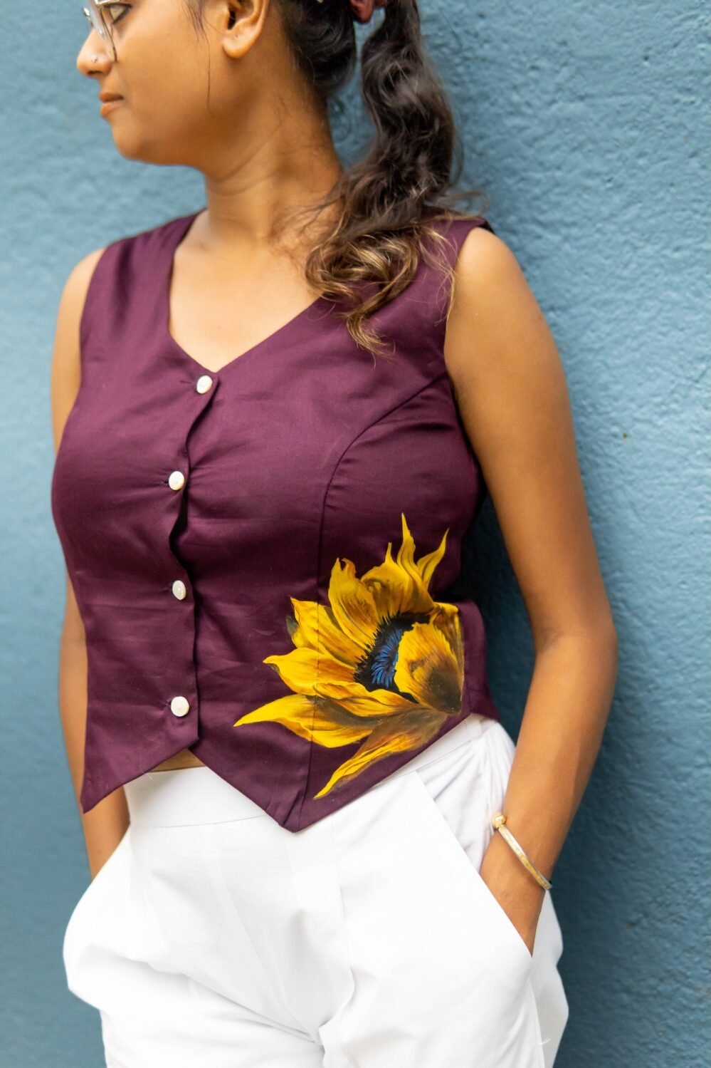 Three-quarter view of a woman styled in a deep purple handpainted sunflower Malai cotton waist coat.