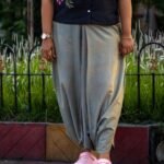 Mid-shot of sage green handloom cotton urban dhoti pants paired with a black floral hand-painted button-down top