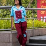 Woman wearing the Sky Blue Maroon Orchid handpainted 3D cotton shirt and pant co-ord set by Aankibukis Couture posing on outdoor steps.