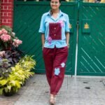 Front view of woman wearing the Sky Blue Maroon Orchid handpainted cotton co-ord set standing in front of a green gate.
