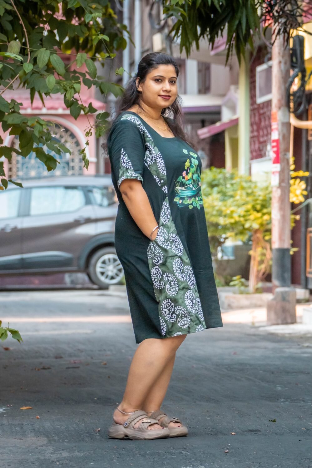 women wearing handpainted boat and lotus motif mid length dress with batik patch, side look