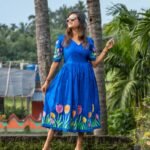 Model wearing a royal blue hand-painted tulip dress with a flared skirt and sweetheart neckline.