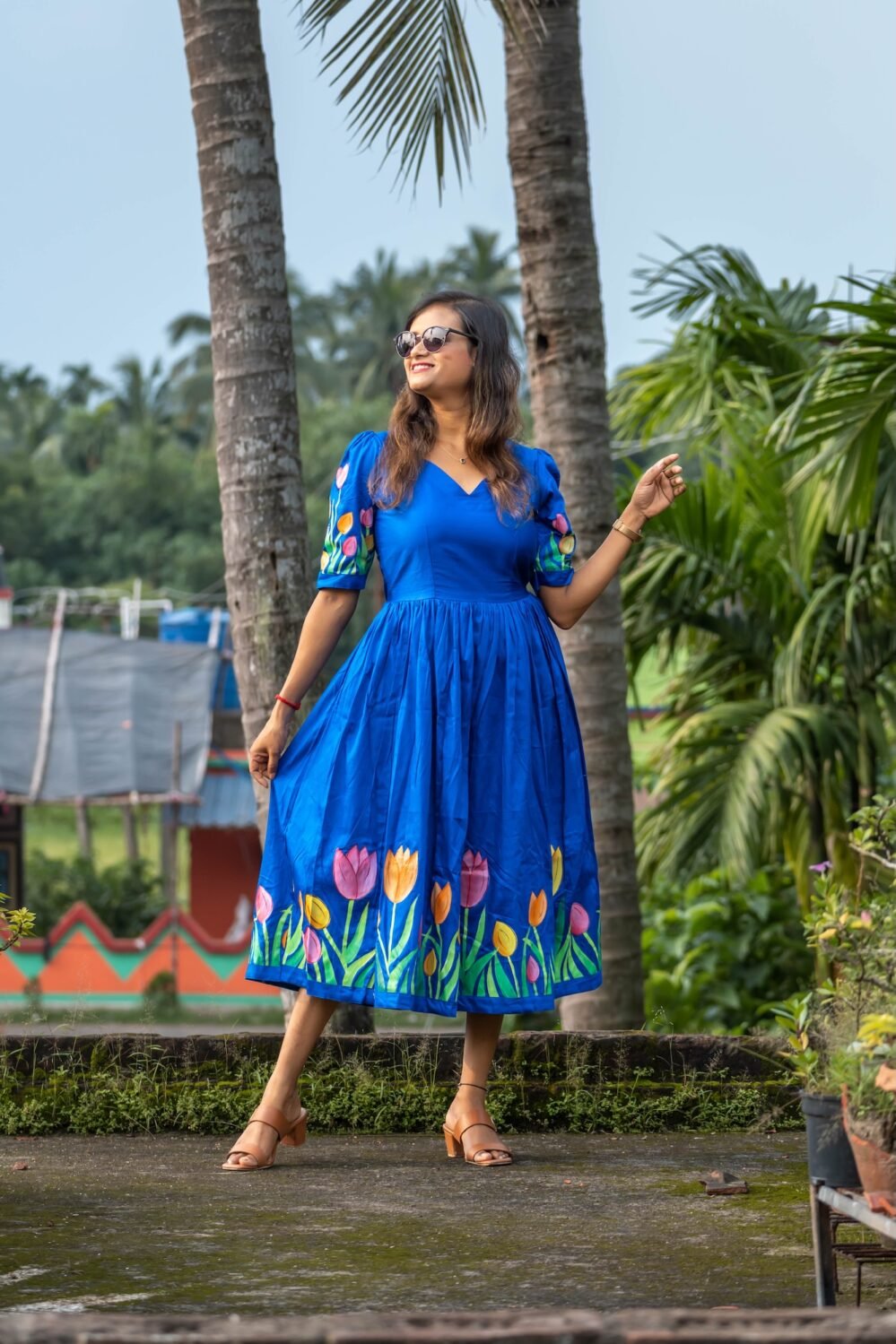 Model wearing a royal blue hand-painted tulip dress with a flared skirt and sweetheart neckline.