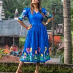 Woman in sunglasses posing in a hand-painted royal blue tulip dress by Aankibukis Couture.