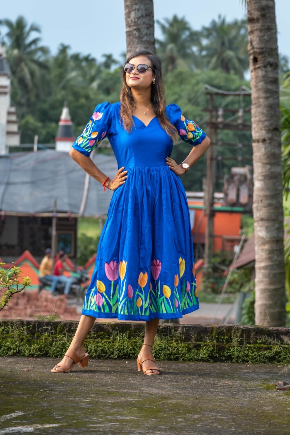 Woman in sunglasses posing in a hand-painted royal blue tulip dress by Aankibukis Couture.