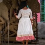 Back view of the off-white Annapurna cotton dress showing the V-neckline piping and gamcha ruffle hem.