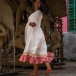 Model in a playful twirl wearing the off-white and red gamcha hand-painted Annapurna dress.