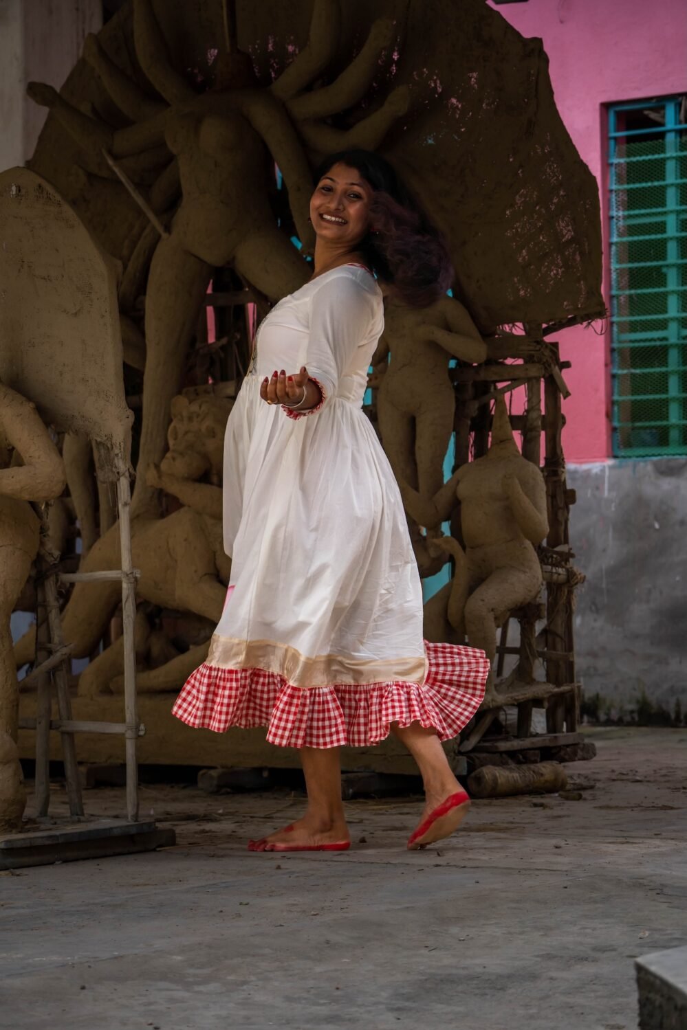 Model in a playful twirl wearing the off-white and red gamcha hand-painted Annapurna dress.