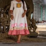 Woman standing in a clay idol workshop wearing the hand-painted Annapurna dress by Aankibukis Couture.