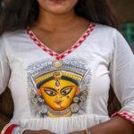 Extreme close-up of the hand-painted Maa Durga face motif and V-neckline with gamcha piping