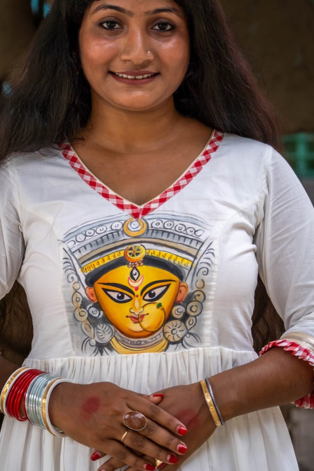 Extreme close-up of the hand-painted Maa Durga face motif and V-neckline with gamcha piping