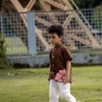 Boy walking outdoors wearing Kisholoy chocolate brown hand-painted floral shirt