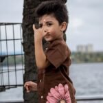 Close-up of boy in Kisholoy chocolate brown hand-painted cotton shirt showing pink floral artwork