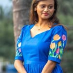 Portrait shot of a woman in a royal blue hand-painted tulip dress with a sweetheart neckline.