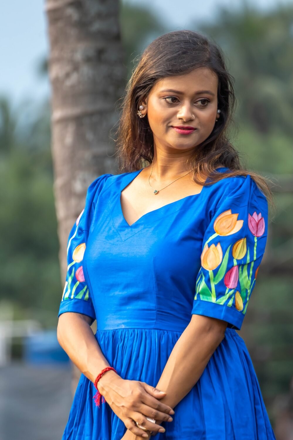 Portrait shot of a woman in a royal blue hand-painted tulip dress with a sweetheart neckline.