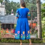 Back view of a woman wearing a royal blue hand-painted tulip dress.