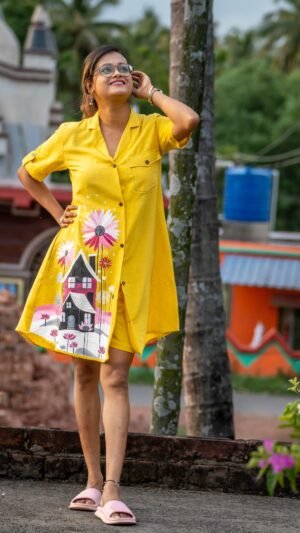 Model posing outdoors wearing bright yellow hand-painted storybook cottage tunic set.