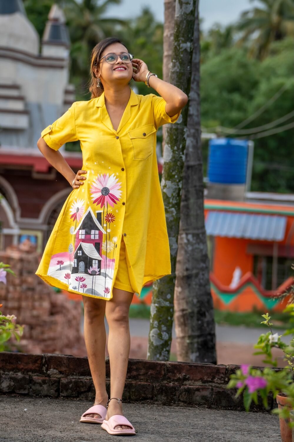 Model posing outdoors wearing bright yellow hand-painted storybook cottage tunic set.
