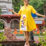 Model casually walking in breathable yellow hand-painted short pant set.